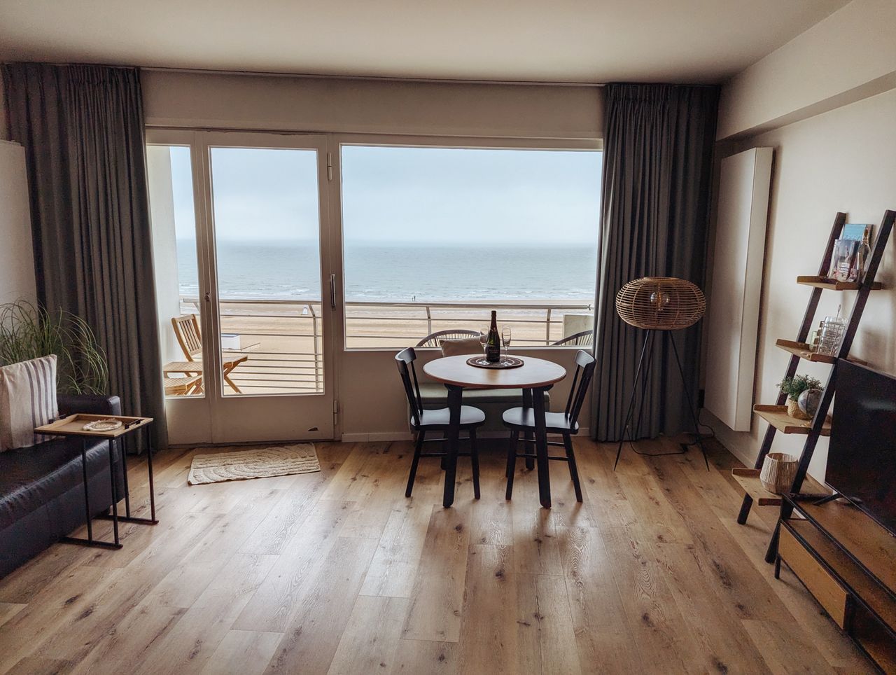 A cozy living room in a beachfront apartment with a stunning ocean view, featuring modern decor.